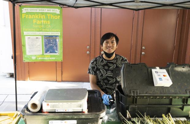 Franklin Thor vendor smiling behind cash register 