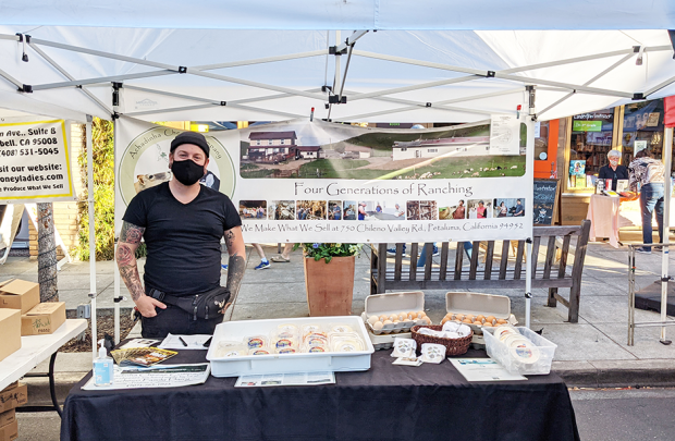 Worker at booth filled with cheeses