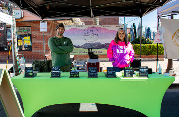 SHE Urban farms owners standing at their booth in the market