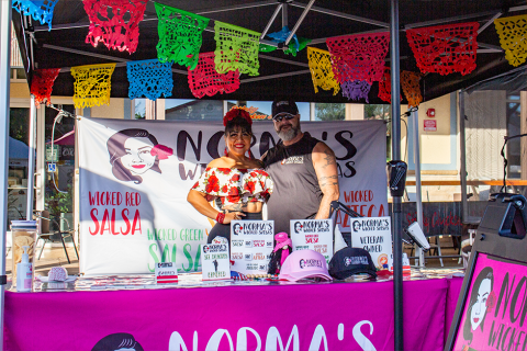 Owners of Norma's Wicked Salsa at their colorfully decorated booth at the Brentwood Farmers' Market
