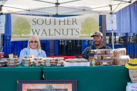 Souther Walnuts owners sitting at their booth at the Brentwood Farmers' Market