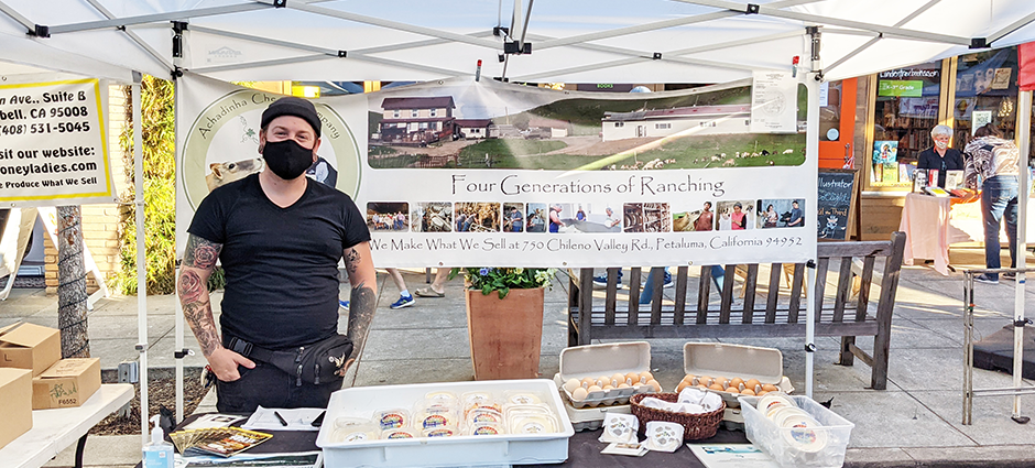 Worker at booth filled with cheeses