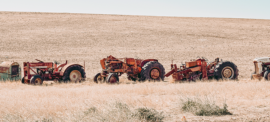 Picture of tractors in a field of dead grass during extreme drought