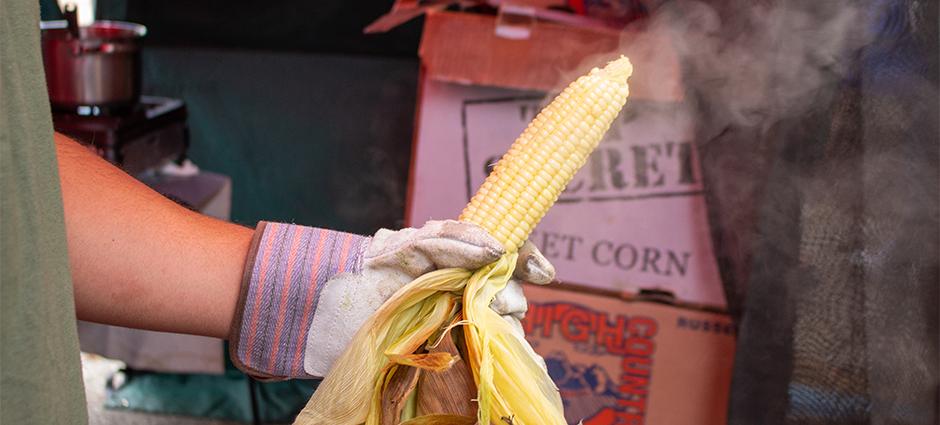 Photo of corn being shucked at market