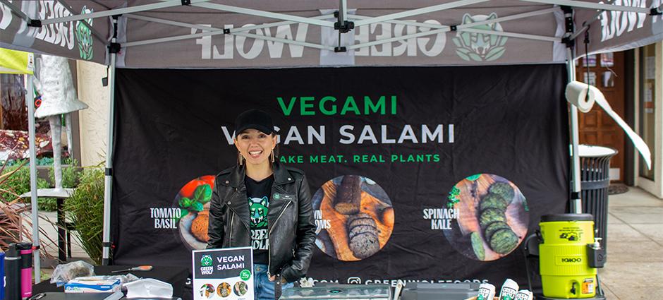 Green Wolf vendor smiling in booth at the market
