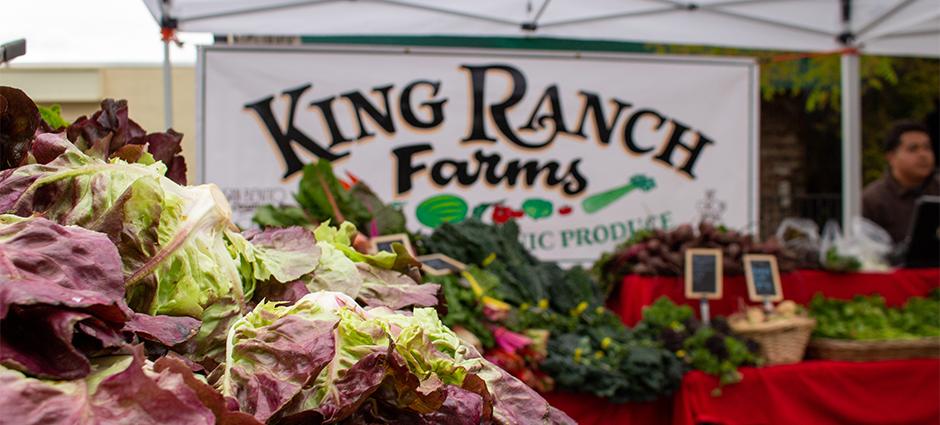 King Ranch certified organic greens near sign