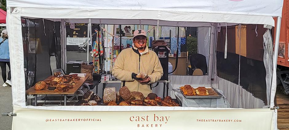 East Bay Bakery stall with a smiling salesman at the Danville Farmers' Market