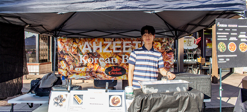Ahzeetu Korean booth at the Brentwood farmers' market, owner standing inside