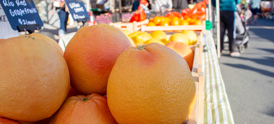 The Brentwood Citrus Company booth at the Brentwood Farmers' Market, surrounded by citrus