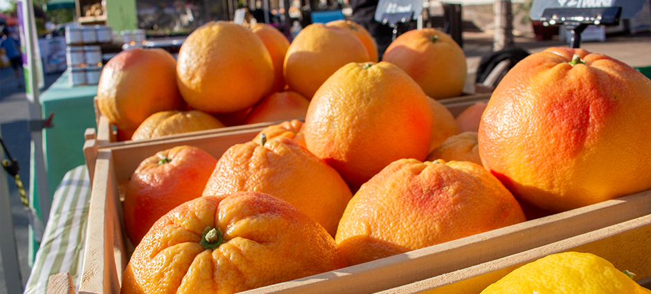 The Brentwood Citrus Company booth at the Brentwood Farmers' Market, surrounded by citrus