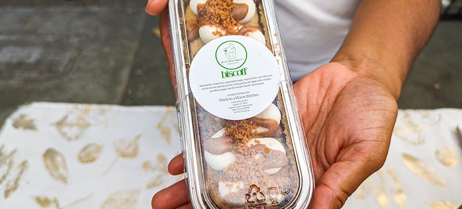 Closeup of vendors hands holding a Green Flour Bakery treat