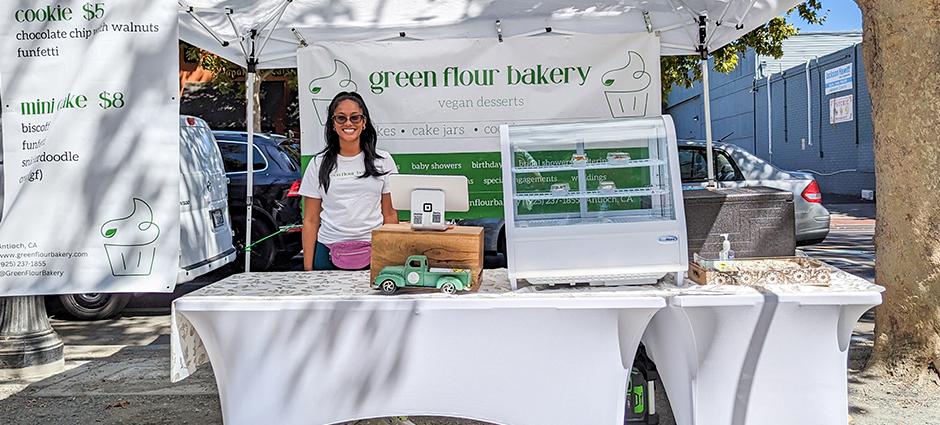 Smiling vendor at Green Flour Bakery stall at Concord Farmers' Market