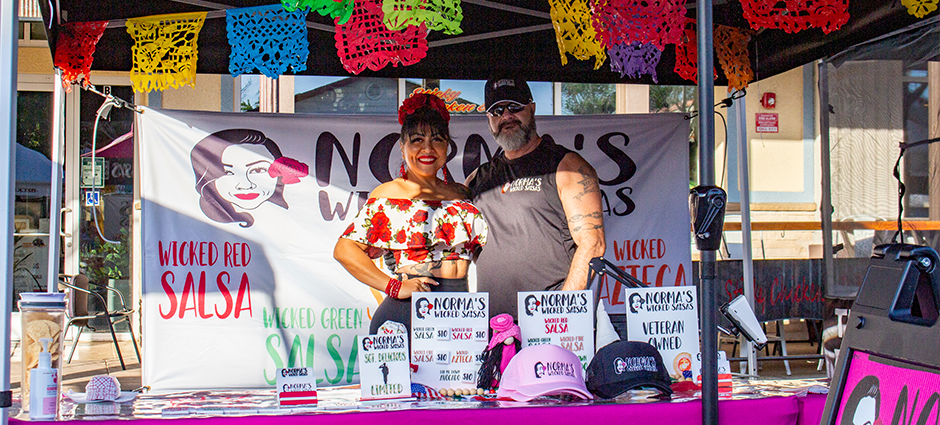 Owners of Norma's Wicked Salsa at their colorfully decorated booth at the Brentwood Farmers' Market