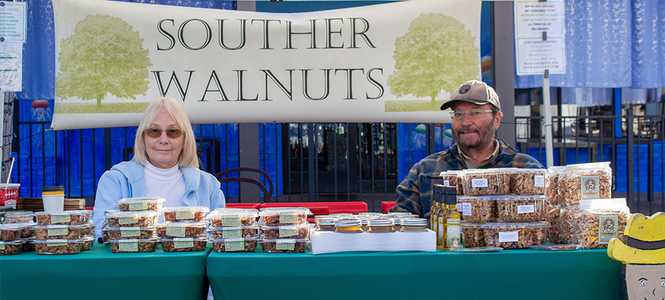 Souther Walnuts owners sitting at their booth at the Brentwood Farmers' Market