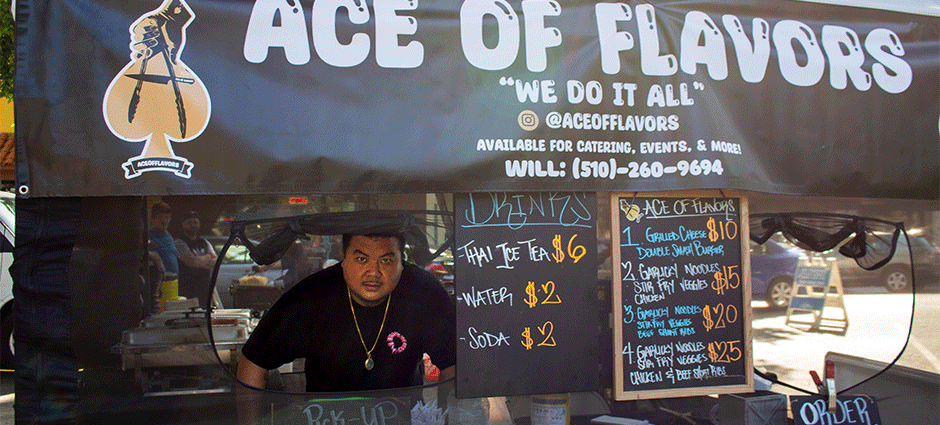 The owner of Ace of Flavors peeking through the window of their tent at the Concord Thursday Farmers' Market