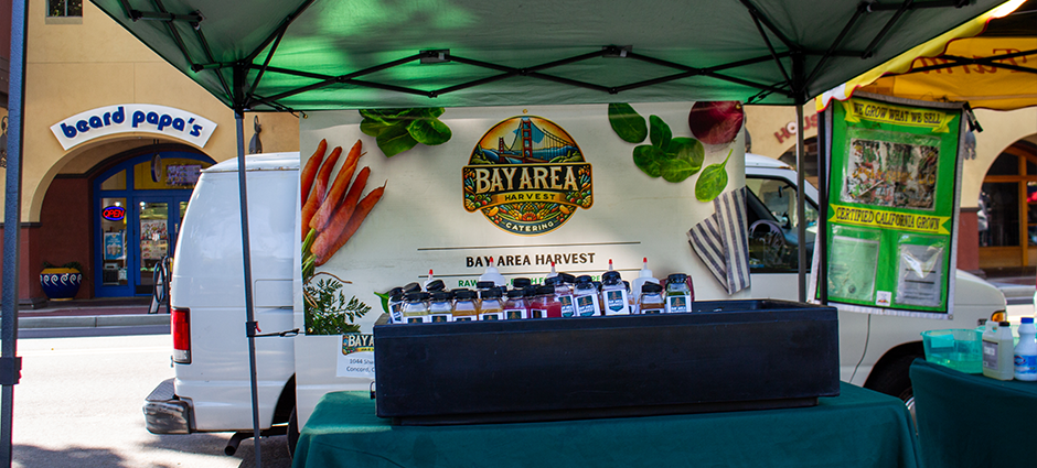Bay Area Harvest stall full of fresh juice bottles at the Concord Farmers' Market