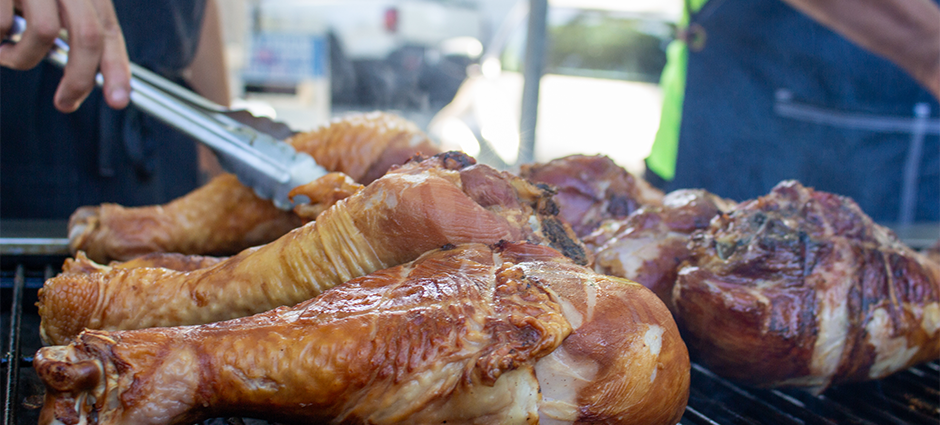 Large turkey legs on the grill at the Cafe Oasis stall at the Concord Farmers' Market
