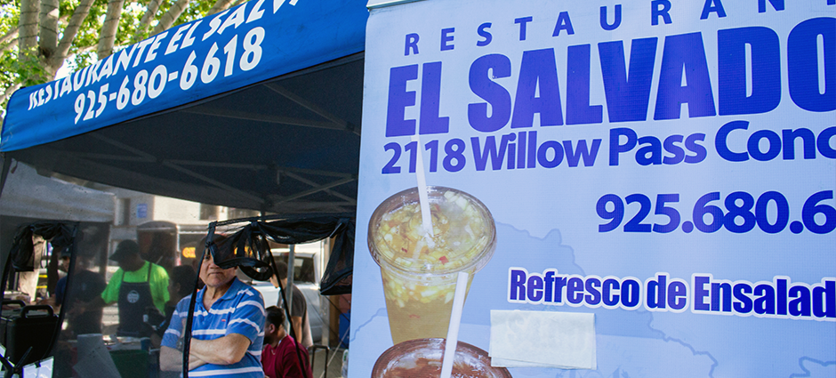 A man stands inside the Restaurante El Salvador stall at the Concord Farmers' Market