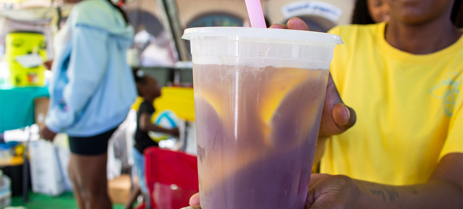 A purple berry lemonade being presented by a worker at Summer JAM Sweets at the Concord Farmers' Market